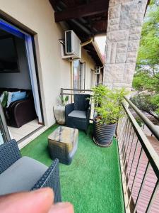a patio with chairs and a table on a balcony at The Wired Nest in Ellisras