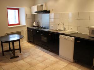 a small kitchen with a sink and a table at Gîte Charmant avec Cheminée, Terrasse et Stationnement - Proche Nancy et Moselle - FR-1-584-50 in Tonnoy +13 photos