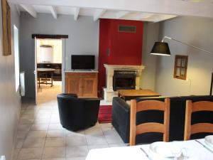 a living room with a couch and a table and a television at Gîte Charmant avec Cheminée, Terrasse et Stationnement - Proche Nancy et Moselle - FR-1-584-50 in Tonnoy