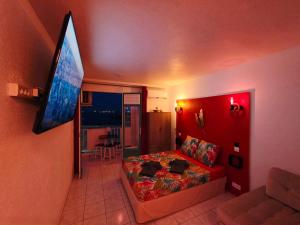 ein Schlafzimmer mit einem Bett und einem Flachbildfernseher in der Unterkunft Sweet Crépuscule - Studio avec Vue Mer Imprenable & Piscine in Les Trois-Îlets + 27 Fotos
