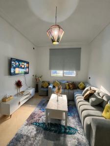 a living room with a couch and a table at Séjour détente près plage des nations in Sale