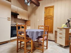 a kitchen with a table and chairs and a refrigerator at Charmant Gîte Vosgien avec Terrasse, Randonnées et Lacs, Proche Alsace et Col du Donon - FR-1-584-54 in Bionville
