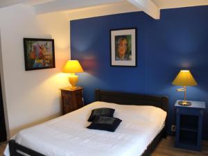 a bedroom with a bed with blue walls and two lamps at Gîte Charmant avec Cheminée, Terrasse et Stationnement - Proche Nancy et Moselle - FR-1-584-50 in Tonnoy