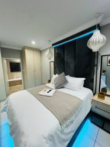 a bedroom with a large white bed with a mirror at The Wired Nest in Ellisras