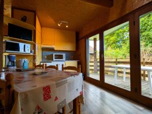 a kitchen with a table with a counter top at Chalet en pleine nature à Orsennes avec étang à proximité, idéal pour 6 personnes et animaux admis - FR-1-591-170 in Orsennes
