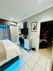 a bedroom with a bed and a desk with a computer at The Wired Nest in Ellisras