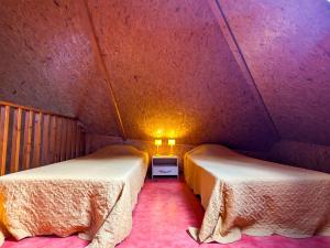 a room with two beds in a small room at Chalet en pleine nature à Orsennes avec étang à proximité, idéal pour 6 personnes et animaux admis - FR-1-591-170 in Orsennes