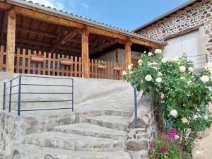 a set of stairs in front of a house with flowers at Ferme du XIXe siècle avec cour fermée et terrasse, proche des gorges de la Loire et du Puy-en-Velay - FR-1-582-187 in Saint-Vincent