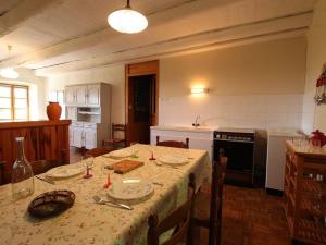 une cuisine avec une table recouverte d'une nappe dans l'établissement Gîte indépendant avec cour privative près de Lavoute-Chilhac et Langeac - FR-1-582-224, à Ferrussac