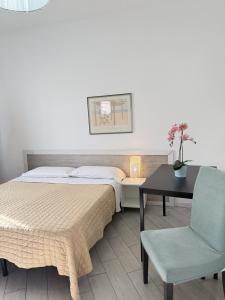 a bedroom with a bed and a table and a chair at EASYROOMS ONE in Parma