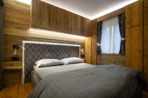a bedroom with a bed and a window at Apt Design a Campiglio 400m funivie in Madonna di Campiglio
