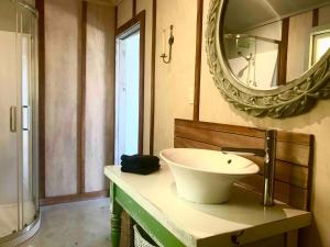 een badkamer met een wastafel en een spiegel bij Bay of Islands - Vineyard Cottage, chic private stunning view in Purerua