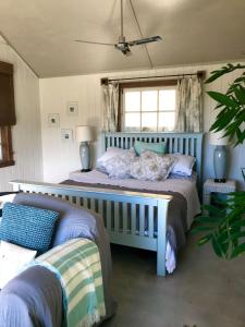 een slaapkamer met twee bedden en een raam bij Bay of Islands - Vineyard Cottage, chic private stunning view in Purerua