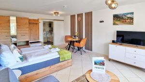 a bedroom with a bed and a television and a table at Naturgenuss in Oy-Mittelberg