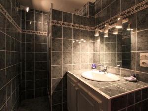 a black tiled bathroom with a sink and a mirror at Gîte en pierre avec terrasses, proche de sites médiévaux, idéal pour famille avec équipements bébé. - FR-1-582-256 in Boisset +8 photos