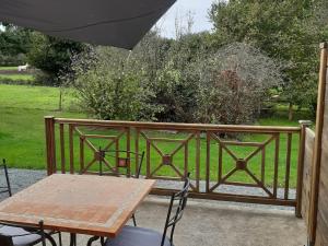 a wooden table and an umbrella on a balcony at Gîte de charme avec WiFi dans ancienne ferme - FR-1-426-457 in Falleron