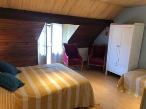 a bedroom with two beds and two chairs at Gîte paisible avec jardin, proche nature et sites historiques, idéale pour détente et activités outdoor. - FR-1-581-138 in Ouerre