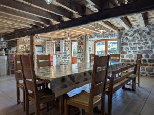 une salle à manger avec une grande table et des chaises en bois dans l'établissement Maison de caractère avec grand terrain, proche d'Arlempdes, labels ECOGÎTE et Tourisme & Handicap - FR-1-582-118, à Arlempdes