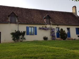 ein Haus mit blauen Fensterläden und einem Blumenkranz in der Unterkunft Gîte Confortable au Cœur du Vignoble de Sancerre avec Internet et Proche de la Loire à Vélo - FR-1-586-3 in Sury-en-Vaux