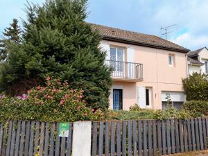 a fence in front of a house with a christmas tree at Maison cosy à Sully-sur-Loire, 5 chambres, terrasse, parking, draps et chauffage inclus - FR-1-590-220 in Sully-sur-Loire