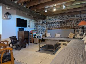 un salon avec un lit et une télévision dans l'établissement Maison de caractère avec grand terrain, proche d'Arlempdes, labels ECOGÎTE et Tourisme & Handicap - FR-1-582-118, à Arlempdes