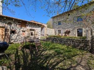 an old stone house with two chairs in the yard at Élégante maison de maître XVIIIe, jardin clos 500m², nature, proche Puy-en-Velay, 11 pers., cosy & confort - FR-1-582-315 in Arsac-en-Velay