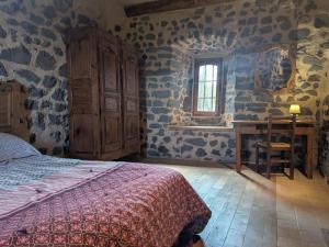 a bedroom with a bed and a desk and a window at Élégante maison de maître XVIIIe, jardin clos 500m², nature, proche Puy-en-Velay, 11 pers., cosy & confort - FR-1-582-315 in Arsac-en-Velay