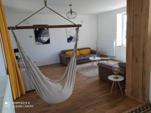 a living room with a hammock hanging from the ceiling at Gîte calme 4 chambres, terrasse privative, draps inclus - Germonville - FR-1-584-167 in Germonville