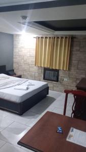 een slaapkamer met een groot bed en een open haard bij Hotel Porto Calem in Sao Paulo