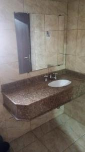 een badkamer met een wastafel en een spiegel bij Hotel Porto Calem in Sao Paulo