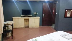 een kamer met een bed en een televisie op een tafel bij Hotel Porto Calem in Sao Paulo