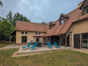 une terrasse avec des chaises bleues, une table et une maison dans l'établissement Maison isolée avec parc, étang privé et à 20 min du Zoo de Beauval - FR-1-591-309, à Vicq-sur-Nahon