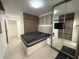 a small room with a bed and a glass wall at cód 63 · Apartamento sofisticado com 2 suítes! in Governador Celso Ramos