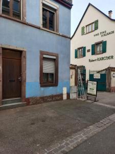 een blauw-wit gebouw met een bord ervoor bij Le nid in Colmar