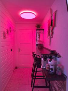ein rosa Zimmer mit einem Tisch und einigen Stühlen in der Unterkunft Sweet Crépuscule - Studio avec Vue Mer Imprenable & Piscine in Les Trois-Îlets