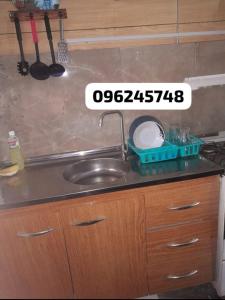 - un comptoir de cuisine avec un évier et un panneau sur celui-ci dans l'établissement Apartamento en playa mansa, à Atlántida