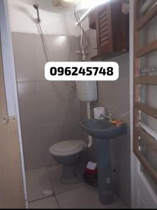 une petite salle de bain avec toilettes et lavabo dans l'établissement Apartamento en playa mansa, à Atlántida