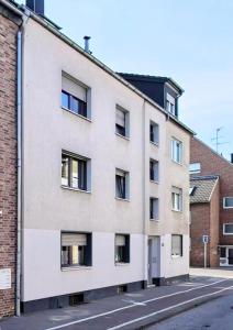 a white building with windows on a street at TuS-FeWo#04 - Serviced & Executive Apartments in Mönchengladbach