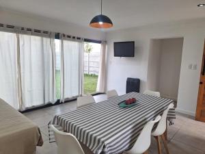 a dining room with a table and chairs and a television at Casa Clara in Tandil