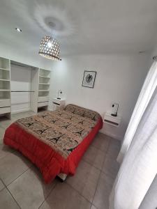 a bedroom with a bed with a red blanket at Casa Clara in Tandil