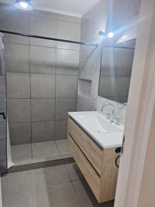 a bathroom with a sink and a shower with a mirror at Casa Clara in Tandil +1 photo