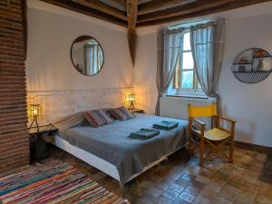 une chambre avec un lit, un miroir et une chaise dans l'établissement Maison de Famille près de Montargis - Élégance et Confort en Forêt - FR-1-590-354, à Paucourt
