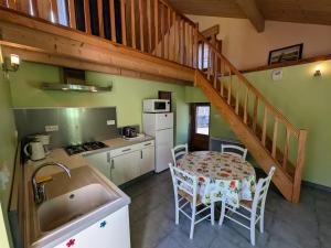 une cuisine avec une table à manger et un escalier dans l'établissement Gîte nature & confort rénové, Plateau des 1000 étangs - WIFI, parking - FR-1-583-302, à Saint-Bresson