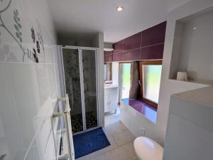 une salle de bains avec une douche en verre et des meubles violets dans l'établissement Gîte nature & confort rénové, Plateau des 1000 étangs - WIFI, parking - FR-1-583-302, à Saint-Bresson 28 autres photos