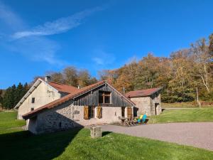 une vieille maison en pierre sur un champ herbeux dans l'établissement Gîte nature & confort rénové, Plateau des 1000 étangs - WIFI, parking - FR-1-583-302, à Saint-Bresson