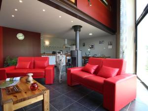un salon avec des chaises rouges et une table dans l'établissement Bergerie moderne au calme, nature luxuriante, proche du Lac de Malaguet - FR-1-582-20, à Céaux-dʼAllègre