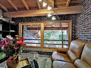 a living room with a couch and a brick wall at Gîte confortable près de la Cascade de la Beaume avec terrasses et parking privatif - FR-1-582-30 in Solignac-sur-Loire