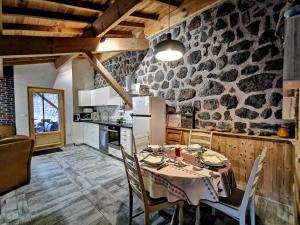 a kitchen and dining room with a table and chairs at Gîte confortable près de la Cascade de la Beaume avec terrasses et parking privatif - FR-1-582-30 in Solignac-sur-Loire +12 photos