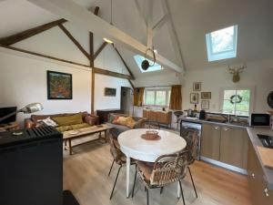 une cuisine et un salon avec une table et des chaises dans l'établissement Gîte cosy en Sologne avec terrasse privative - FR-1-590-549, à Villemurlin