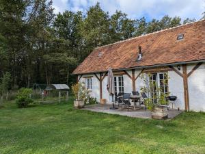 Ce cottage blanc dispose d'une terrasse dans la cour. dans l'établissement Gîte cosy en Sologne avec terrasse privative - FR-1-590-549, à Villemurlin